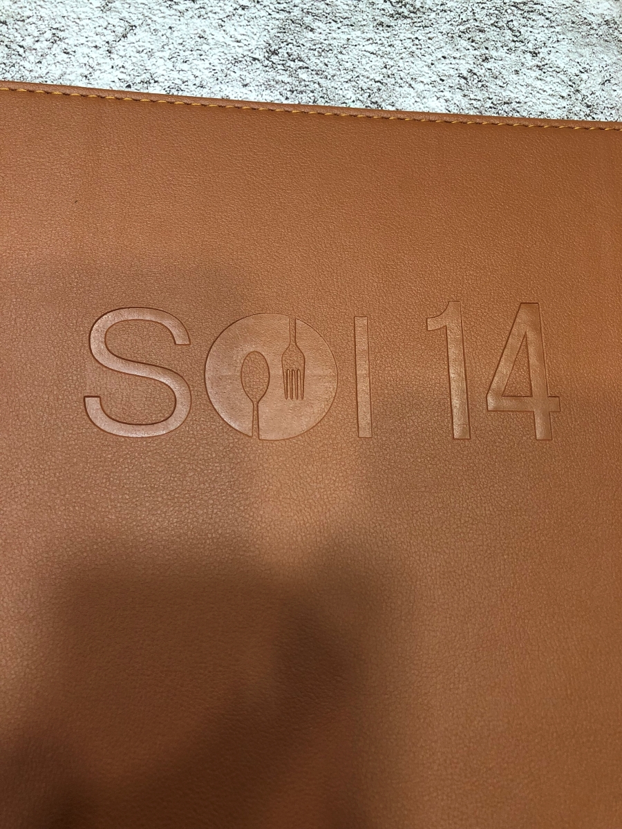 Logo application, stitching and binding options are selected to complement the menu design and maintain brand consistency.